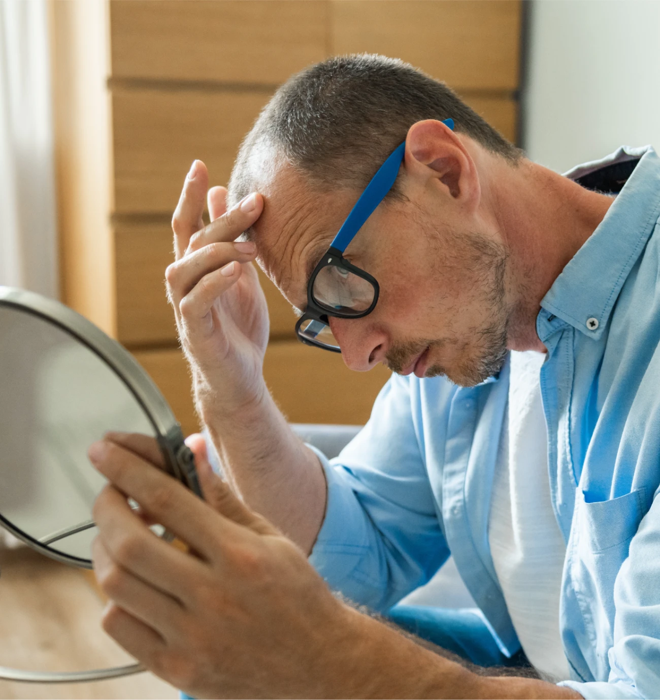 man stressed looking at hair