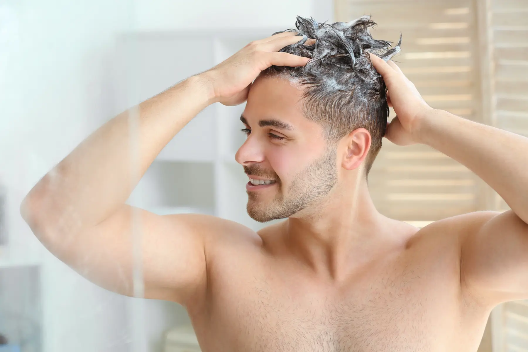 Man applying shampoo, enhancing hair health and cleanliness.